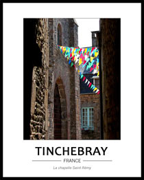 Vue sur la chapelle Saint-R�my dans l'axe d'un ruelle perpendiculaire, on aper�oit la fa�ade de la chapelle, les vielles pierres monochromes de l'�difice sont rehauss�s par des fanions multicouleurs tendus dans la ville � l'occasion du comice.