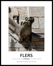 vue de face d'une gargouille de l'�glise, elle a de grandes oreilles et des ailes. Au fond, ornements et pierres taill�es de l'�glise dont on voit les traces de la taille