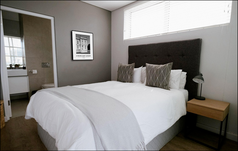 Chambre d�h�tel d�cor�e avec photo noir et blanc d�un lion sculpt� du ch�teau du Bourg-Saint-L�onard, d�tail architectural du XVIIIe si�cle �voquant prestige et raffinement