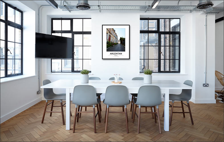 Salle de réunion moderne et lumineuse, au style épuré et professionnel. Une grande table blanche est entourée de chaises design aux tons gris, posées sur un parquet en chevrons qui apporte une touche chaleureuse à l’ensemble.
Les grandes fenêtres industrielles laissent entrer abondamment la lumière naturelle, renforçant l’impression d’espace et de clarté. Quelques plantes disposées sur la table ajoutent une note végétale discrète.
Au mur, un cadre met en valeur une photographie d’une rue fleurie d’Argentan, sans voiture, offrant une scène paisible et esthétique. Cette image apporte une dimension locale et apaisante, contrastant avec l’environnement de travail contemporain tout en humanisant l’espace.