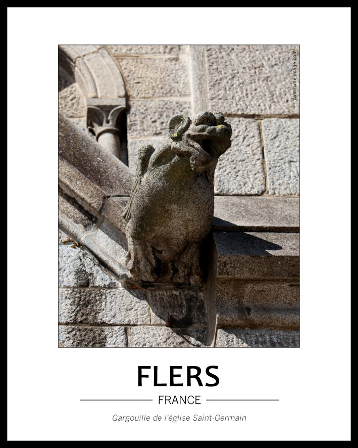 Cliquez pour agrandir vue de face d'une gargouille de l'église, elle a de grandes oreilles et des ailes. Au fond, ornements et pierres taillées de l'église dont on voit les traces de la taille