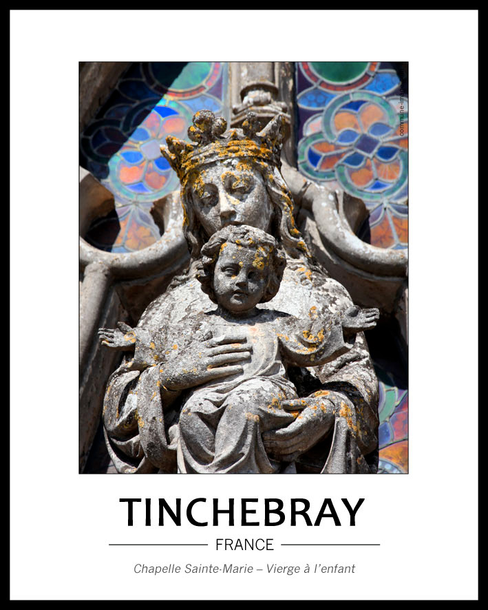 vue tr�s rapproch�e de la vierge � l'enfant devant la rosace. On voit juste le buste de la vierge et l'enfant dans son int�gralit�, les bras �cart�s. la pierre grise de l'�difice est raviv�e par les couleurs marqu�es des vitraux de la rosace.