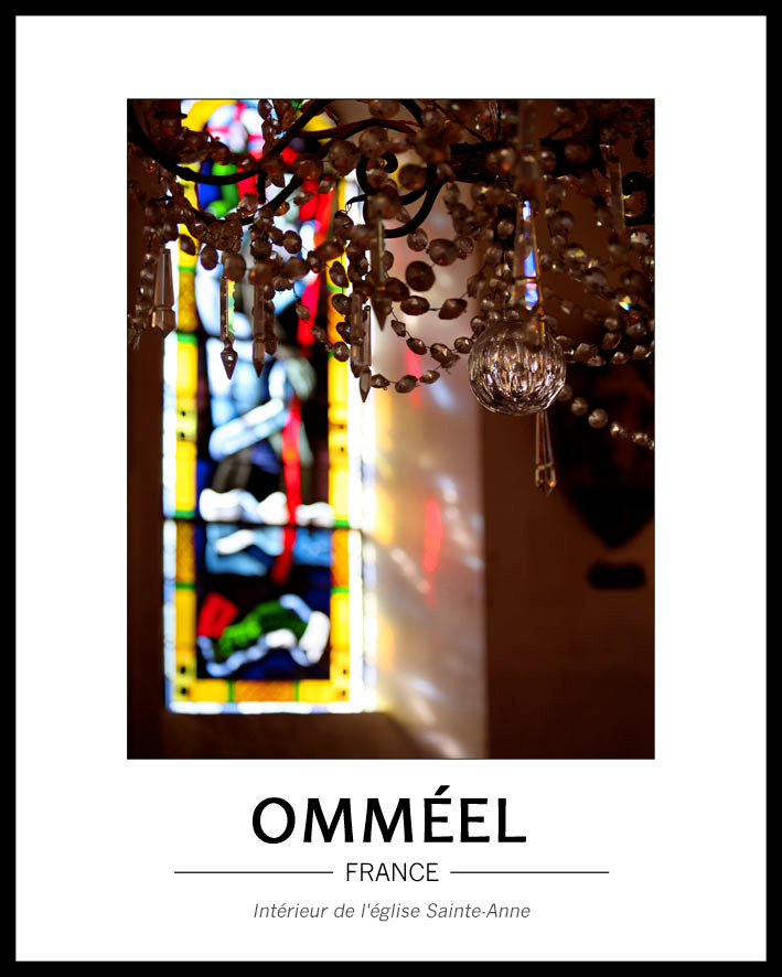 Jeux de lumi�re dans l'�glise avec en premier plan le bas d'un lustre � pampilles et au fond, flou, un virtrail apportant lumi�re et couleurs ton jaune