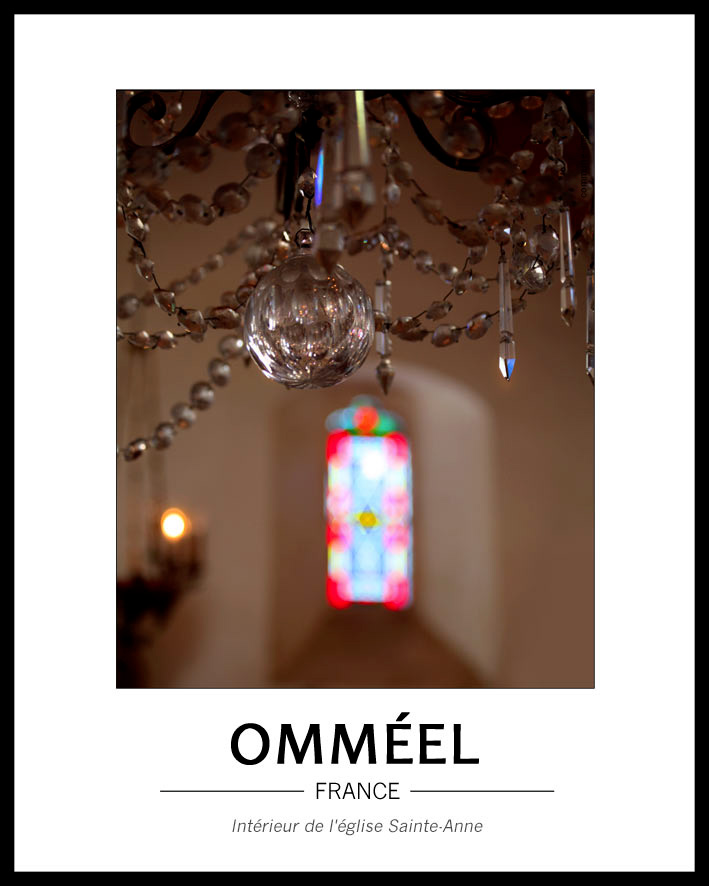 Jeux de lumi�re dans l'�glise avec en premier plan le bas d'un lustre � pampilles et au fond, flou, un virtrail apportant lumi�re et couleurs ton rouge