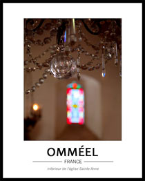 Jeux de lumi�re dans l'�glise avec en premier plan le bas d'un lustre � pampilles et au fond, flou, un virtrail apportant lumi�re et couleurs ton rouge